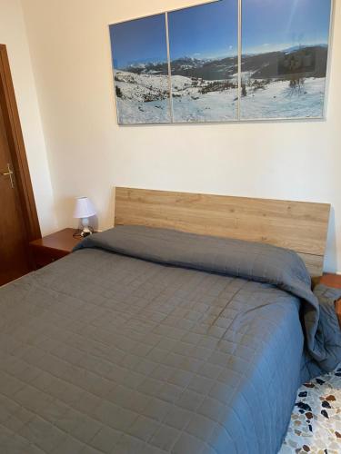 a bedroom with a bed with three pictures on the wall at Casa vacanze Lago di Campotosto in Campotosto