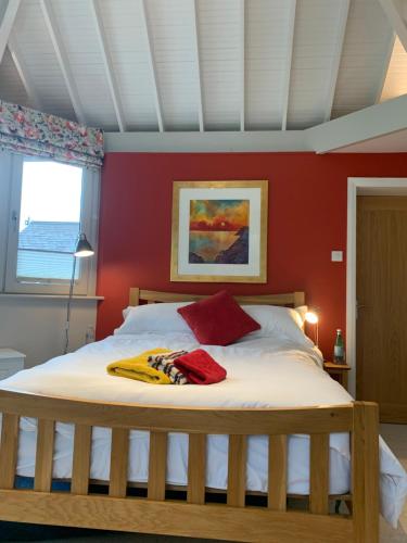 um quarto com uma cama grande e paredes vermelhas em Brookfield Cottage em West Kirby