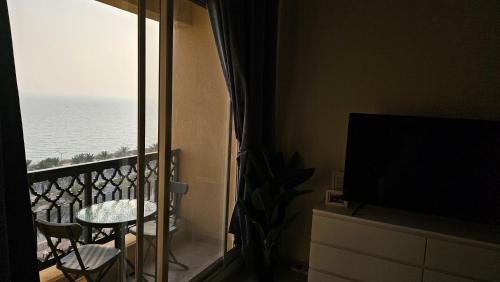 a room with a balcony with a view of the ocean at Full Sea view studio in Ras al Khaimah