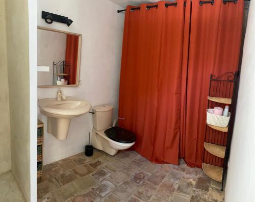 een badkamer met een oranje douchegordijn en een toilet bij Havre paisible à la Campagne in Salon-de-Provence