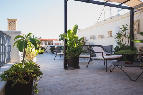 a patio with chairs and plants on a balcony at RIAD Comfort Rooms in San Vito lo Capo