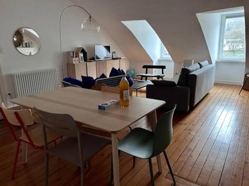 un salon avec une table, des chaises et un canapé dans l'établissement L'Odet - Superbe vue sur les quais - Hyper Centre, à Quimper