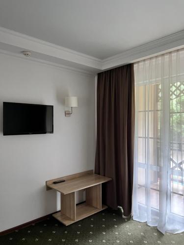 a room with a tv and a table and a window at Vik-Jan in Khmelʼnytsʼkyy