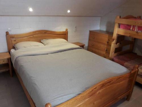 - une chambre avec un lit en bois et une commode dans l'établissement Appartement Le Carlina 22B -MERCI DE LIRE TOUT ET disposition des chambres pour éviter une mauvaise note - Ce nest PAS un Hôtel - MINIMUM 5 nuits - sans le linge de maison - Vue sur le Criou - Sil y a de la place sur le parking, vous pouvez vous y garer, à Samoëns