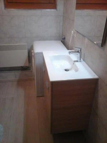 La salle de bains est pourvue d'un lavabo blanc et de parquet. dans l'établissement Appartement Le Carlina 22B -MERCI DE LIRE TOUT ET disposition des chambres pour éviter une mauvaise note - Ce nest PAS un Hôtel - MINIMUM 5 nuits - sans le linge de maison - Vue sur le Criou - Sil y a de la place sur le parking, vous pouvez vous y garer, à Samoëns