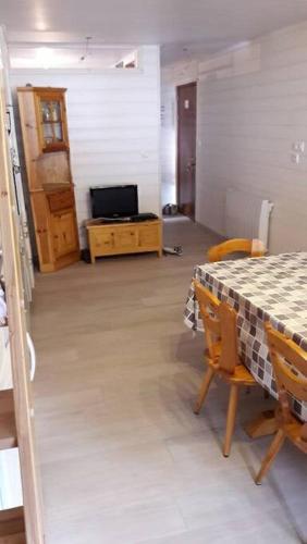 une pièce avec une table et des chaises et une pièce avec une table et une télévision dans l'établissement Appartement Le Carlina 22B -MERCI DE LIRE TOUT ET disposition des chambres pour éviter une mauvaise note - Ce nest PAS un Hôtel - MINIMUM 5 nuits - sans le linge de maison - Vue sur le Criou - Sil y a de la place sur le parking, vous pouvez vous y garer, à Samoëns