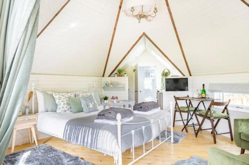 a bedroom with a white bed and a table and chairs at South Barlogan Farm in Bridge of Weir