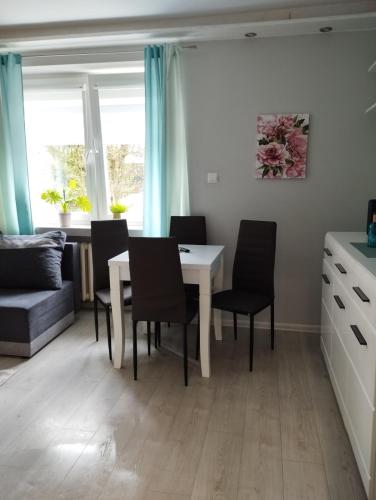 a kitchen and dining room with a table and chairs at Apartament Agata in Giżycko