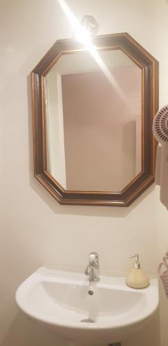 lavabo en el baño con espejo en la pared en B&B La Fontanina en Siena