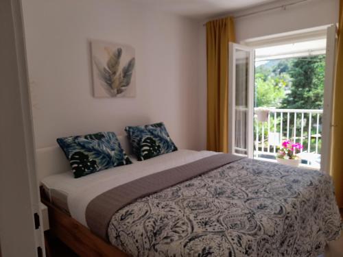 a bedroom with a bed and a window at Apartment Pinia with free parking in Lovran