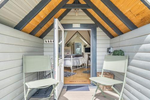 a porch with two chairs and a door to a bedroom at South Barlogan Farm in Bridge of Weir