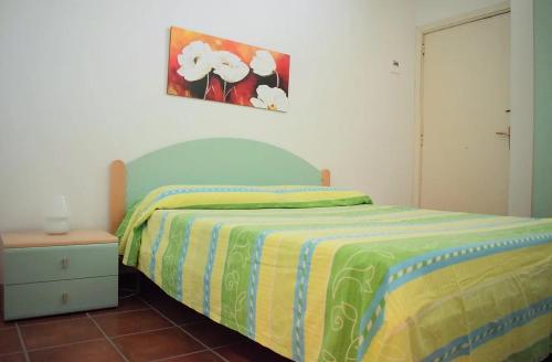 1 dormitorio con 1 cama con manta verde y amarilla en Appartamento Letojanni Gabbiano Sul Mare, en Letojanni
