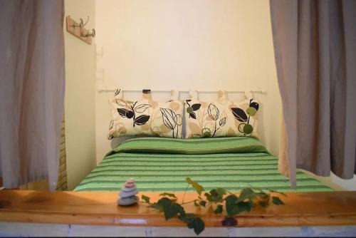 Dormitorio pequeño con cama con sábanas verdes en Appartamento Letojanni Gabbiano Sul Mare, en Letojanni