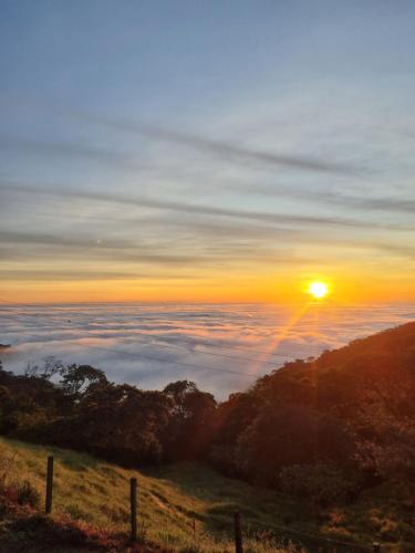 a view of the sun rising above the clouds at Senderos Glamping in Villavicencio