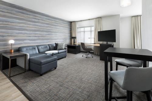 a hotel room with a couch and a desk at Residence Inn Long Island Garden City in Garden City