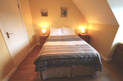 a bedroom with a bed with two lamps on both sides at Long Quay Apartments, Clonakilty in Clonakilty