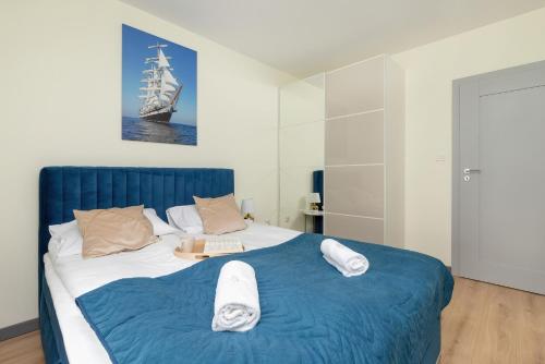 a bedroom with a large bed with a ship on it at Apartment Starowiejska with Balcony & Parking next to Gdańsk Arena Stadium by Renters in Gdańsk