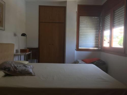 een slaapkamer met een bed en 2 ramen bij Apartament amb vistes in Platja  d'Aro