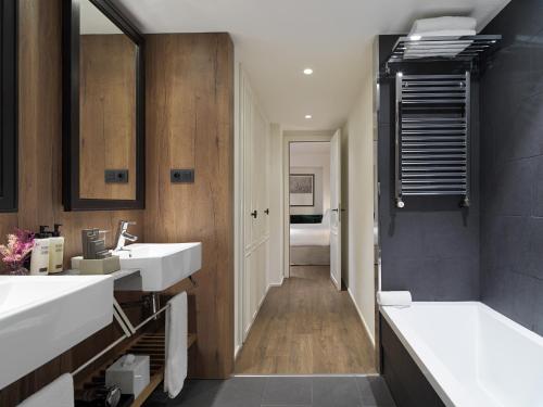 a bathroom with two sinks and a tub at H10 Casanova in Barcelona