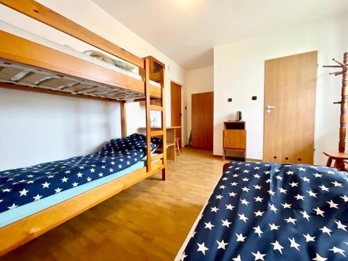 a bedroom with two bunk beds with an american flag blanket at Promyk in Władysławowo