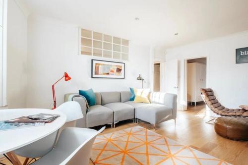 uma sala de estar com um sofá e uma mesa em BRIGHTON BEACH APARTMENT Parking Free On-site em Brighton & Hove
