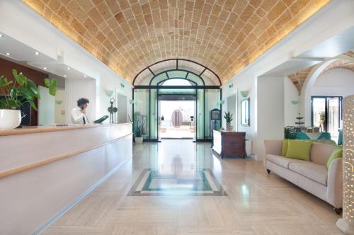 um hall de entrada de um edifício com um homem de pé em um balcão em Grand Hotel Mediterraneo em Santa Cesarea Terme