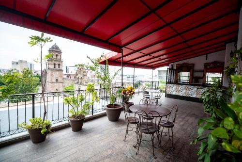 a patio with a table and chairs on a balcony at Hotel Santiago De Compostela - Guadalajara Centro Historico in Guadalajara