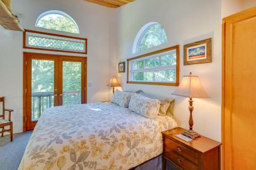 a bedroom with a bed and two windows at Enchanting Escape with Hot Tub, Decks and Views! in McKenzie Bridge