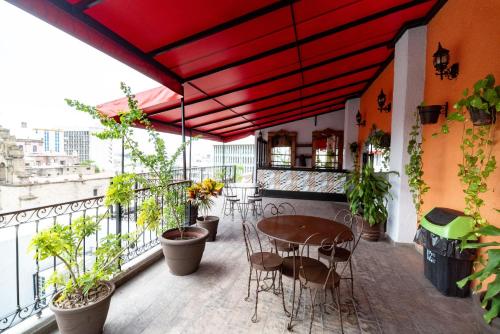 a patio with a table and chairs on a balcony at Hotel Santiago De Compostela - Guadalajara Centro Historico in Guadalajara