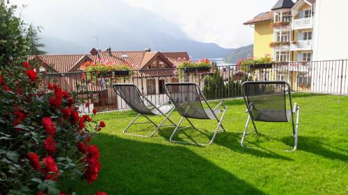 two chairs sitting in the grass in a yard at Casa Vacanze Dorigoni in Molveno