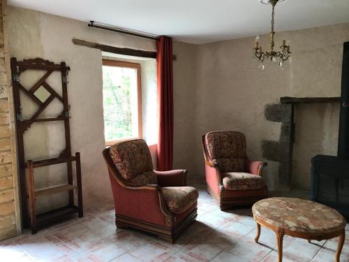 a living room with two chairs and a table at Gîte de Kergoubleau in Kergoubleau