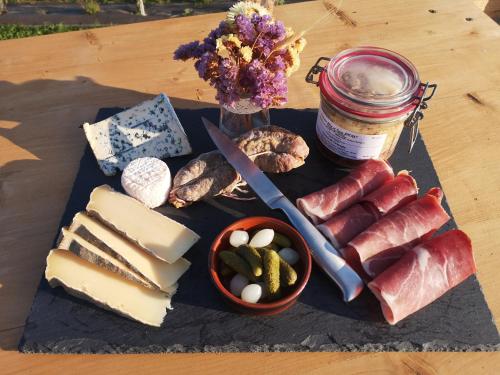 a tray of cheese and meats and a jar of jam at Sous les Toiles de PauTiLou in Molles