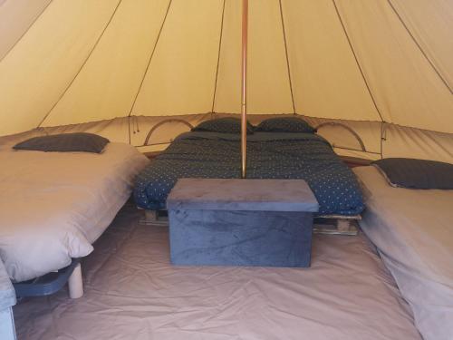 a tent with two beds and a table in it at Sous les Toiles de PauTiLou in Molles