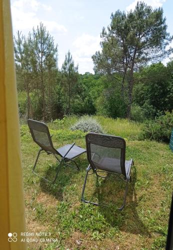 deux chaises assises dans l'herbe dans un champ dans l'établissement Quietude, à Périgueux