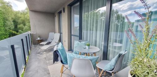 a balcony with chairs and a table and some windows at Marina Apartment by Dora in Keszthely