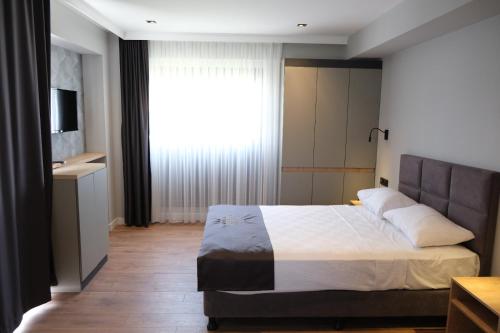 Postel nebo postele na pokoji v ubytování Grand Müdüroğlu Hotel
