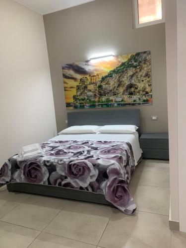 1 dormitorio con 1 cama con una pintura en la pared en B&B Eden, en Scafati