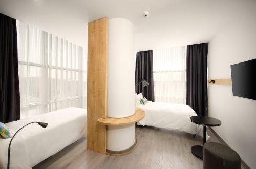 a hotel room with two beds and a tv at Ibis Istanbul Airport in Istanbul