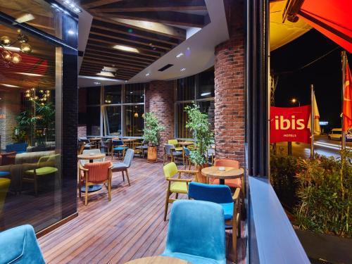 a restaurant with tables and chairs in a building at Ibis Istanbul Airport in Istanbul