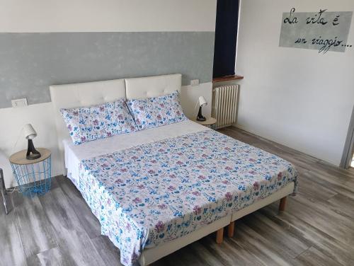 een slaapkamer met een bed met een blauw en wit dekbed bij Sleep & Fly Malpensa in Case Nuove