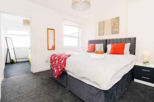 een slaapkamer met een groot bed met oranje kussens bij Furnished Home in Birmingham in Birmingham