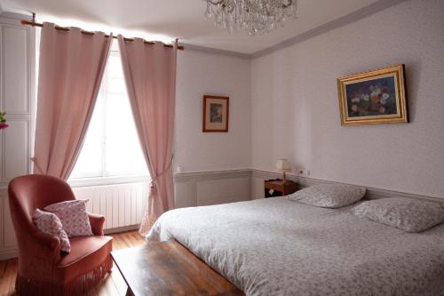 1 dormitorio con 1 cama, 1 silla y 1 ventana en les chambres fleuries, en Saint-Benoît-du-Sault