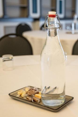 a bottle of water on a plate on a table at Almondsbury Inn & Lounge in Almondsbury
