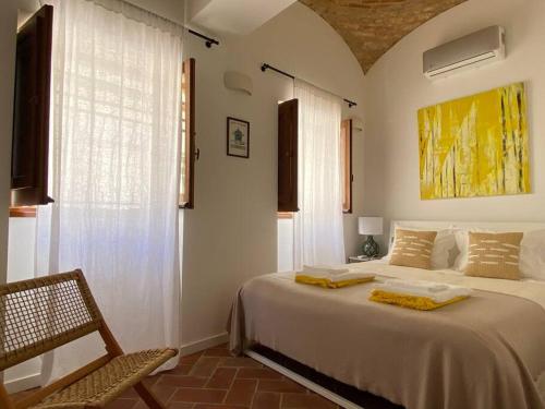 a bedroom with a large white bed and a chair at CasaWolhão JANEIRO - tour du pêcheur vue mer in Olhão