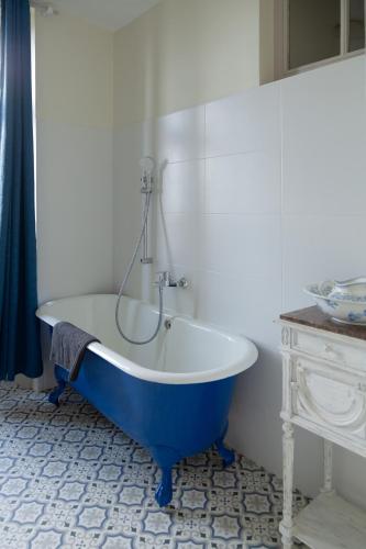 une baignoire bleue et blanche dans une salle de bain dans l'établissement les chambres fleuries, à Saint-Benoît-du-Sault