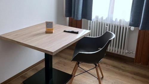 a wooden table with a pen and a chair at Gästezimmer Drexl in Türkenfeld