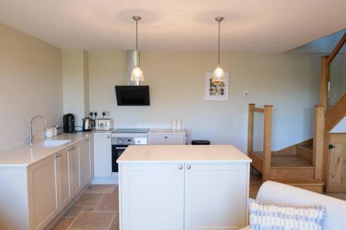a kitchen with white cabinets and a counter top at Greentrees Esate - The Ash Cottage in Haywards Heath
