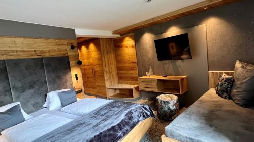 a bedroom with a large bed and a television at Frühstückspension Astoria in Sölden