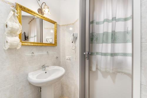 ein weißes Badezimmer mit einem Waschbecken und einem Spiegel in der Unterkunft Casa Liori 2 - Dolianova in Dolianova