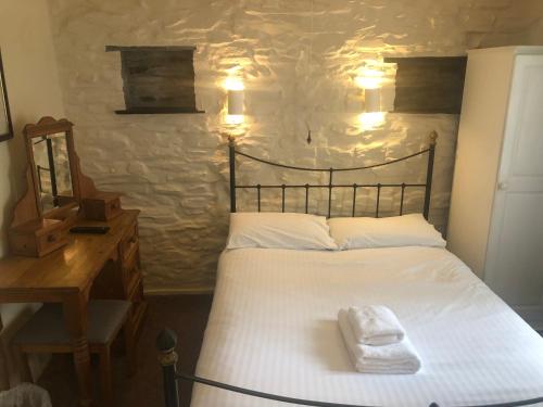 a bedroom with a bed with a white towel on it at Trehellas House Hotel & Courthouse restaurant in Bodmin